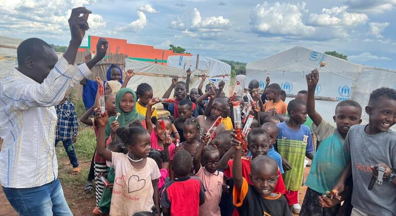 أطفال سودانيون لاجئون في يوغندا يحملون هدايا تلقوها بمناسبة عيد الفطر المبارك.